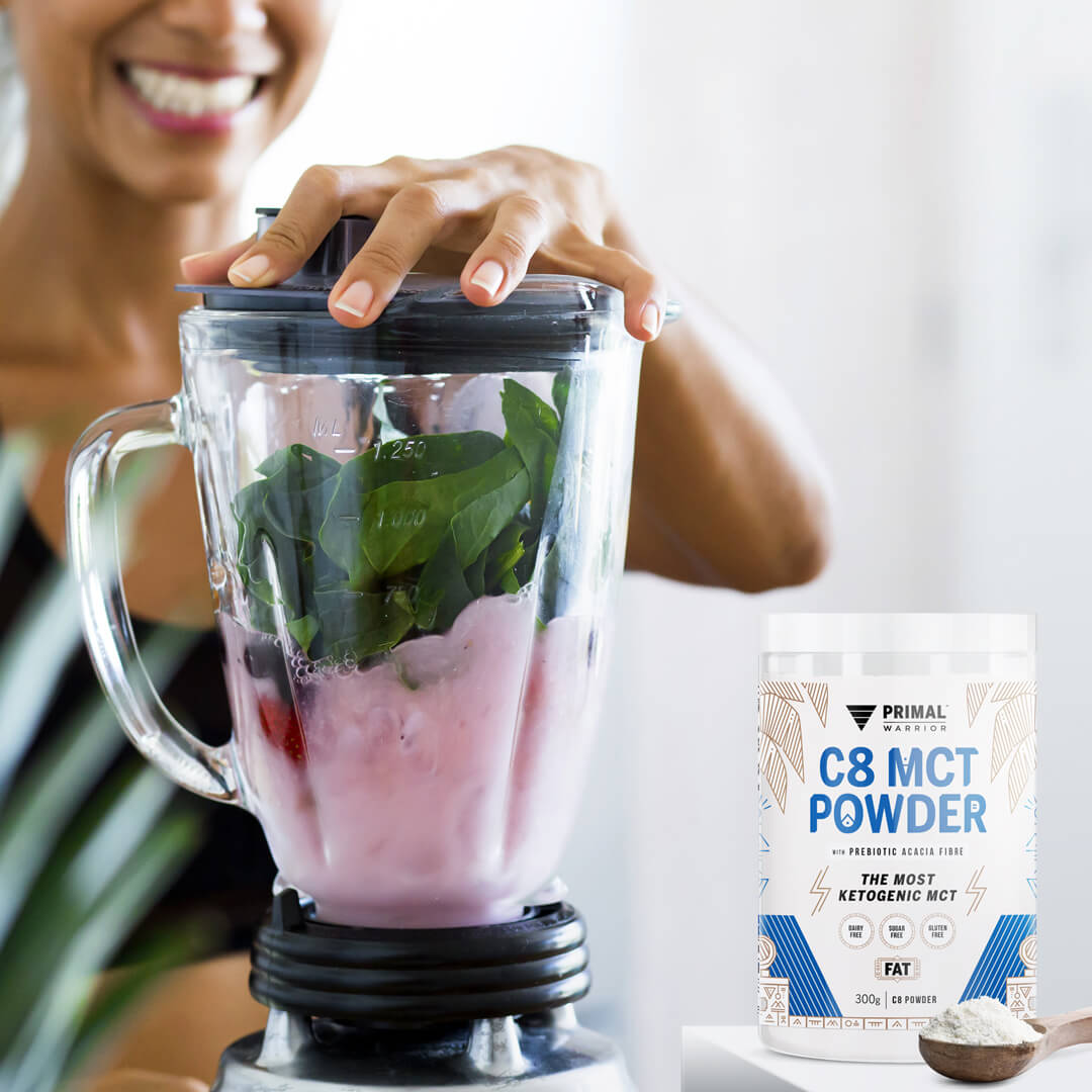 Image of a fit woman blending a healthy spinach and berry smoothie with Primal Warrior C8 MCT Creamer